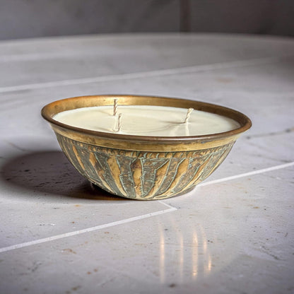 Decorative ceramic bowl with gold and green patterns on a marble surface