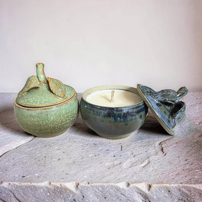 Three ceramic containers with lids on a textured surface