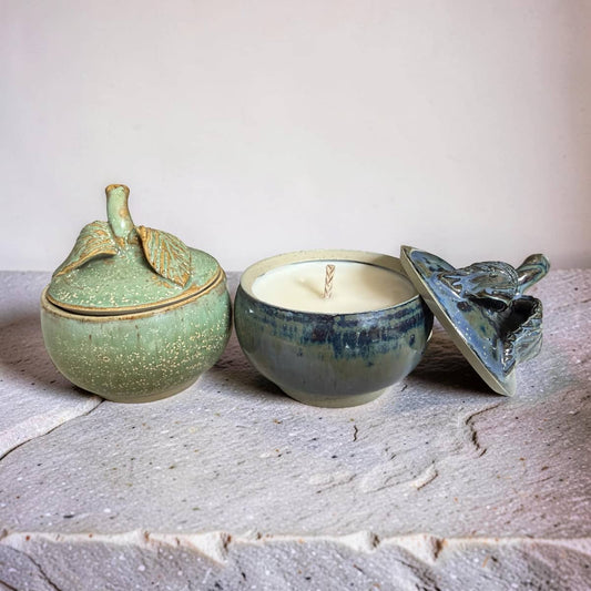 Three ceramic containers with lids on a textured surface