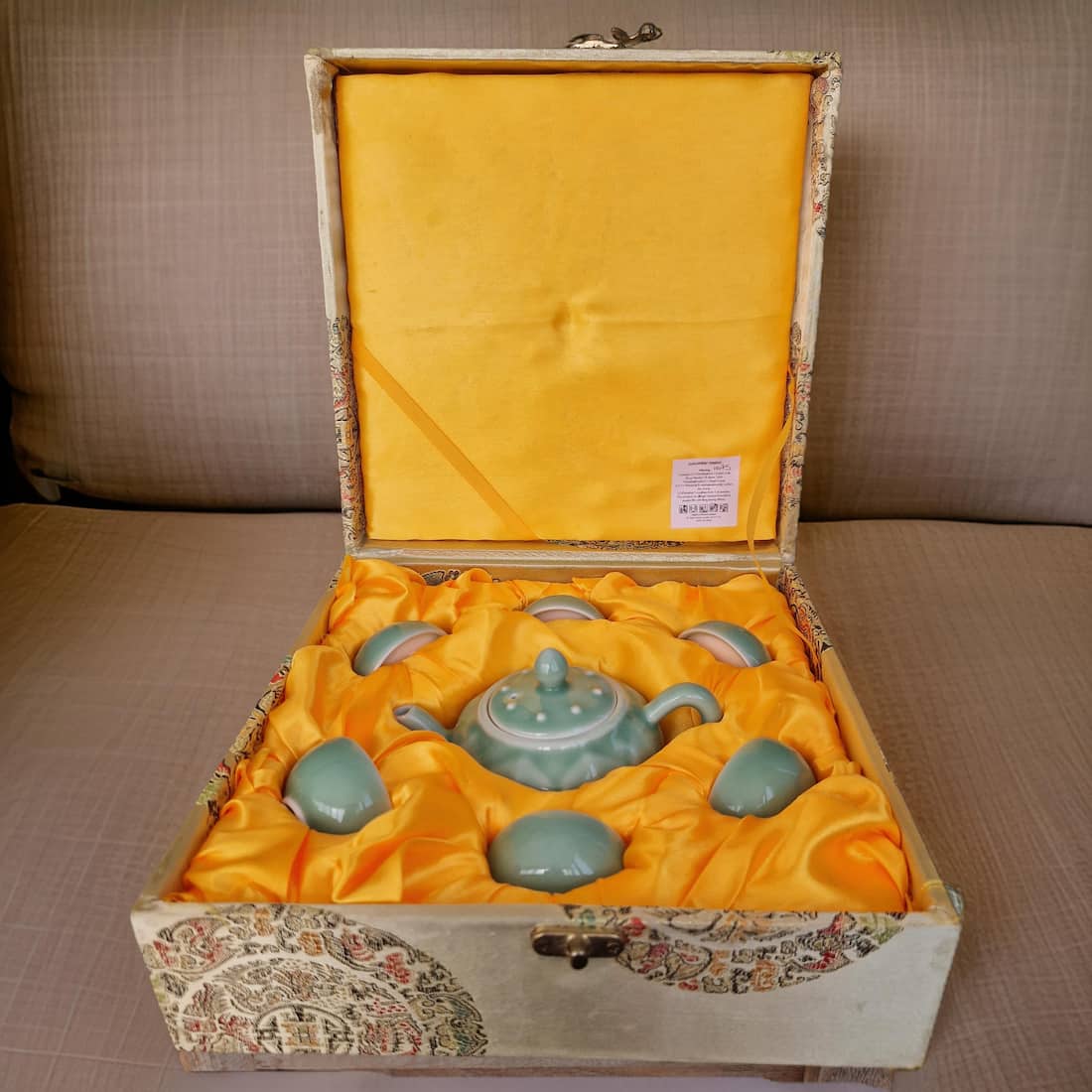 Tea set in a decorative box with yellow interior