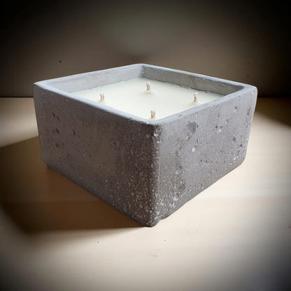 Square concrete candle holder on a neutral background