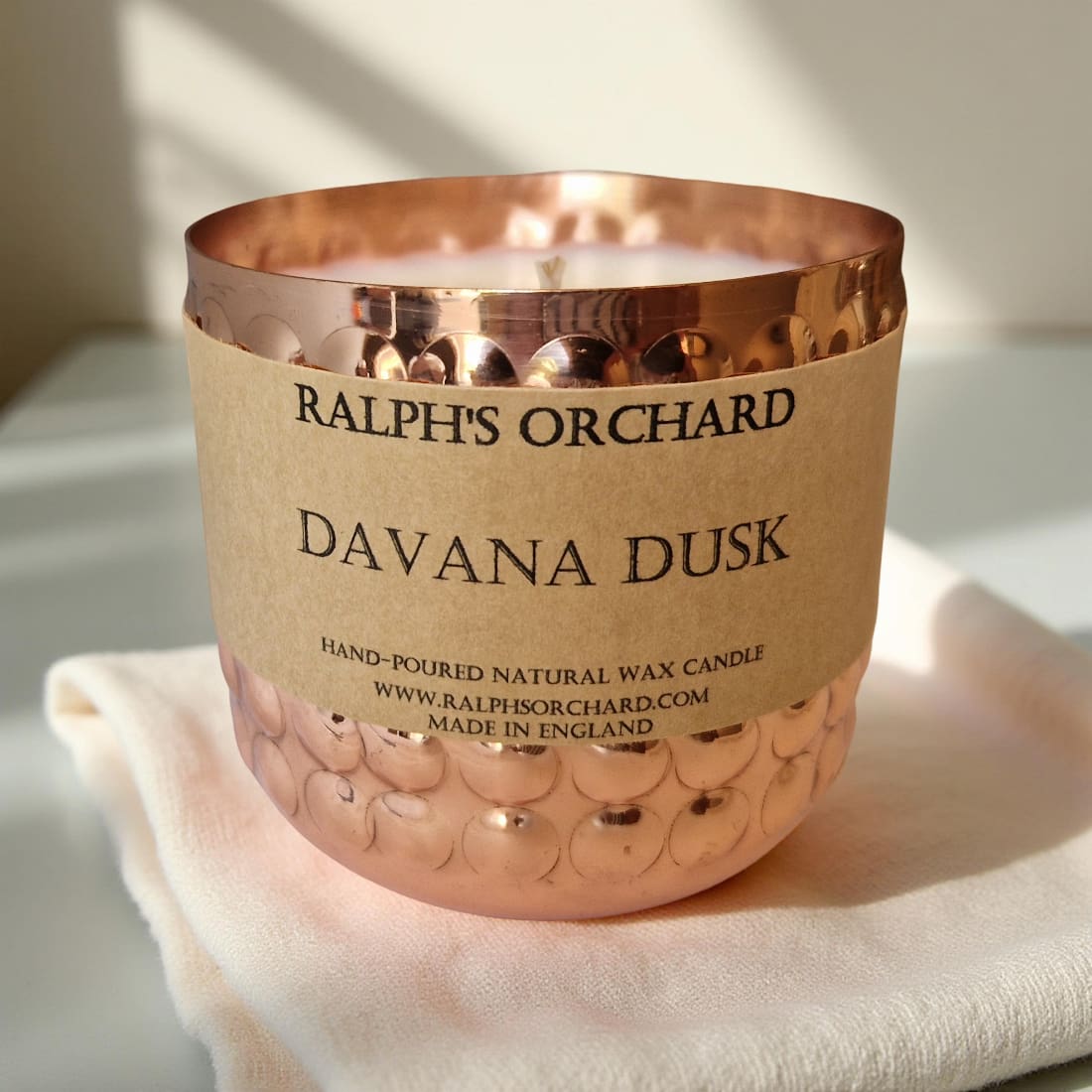Candle with a copper lid and label on a light background