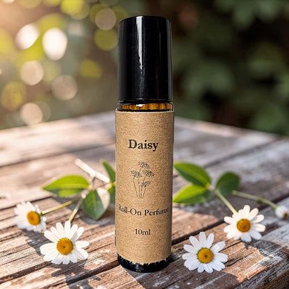 Roll-on perfume bottle labeled 'Daisy' on a wooden surface with daisies.