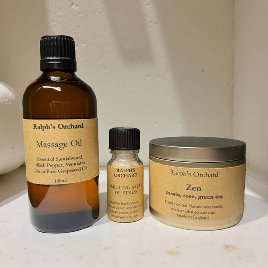 Three Ralph's Orchard products including a massage oil bottle, a small bottle, and a jar on a white surface.