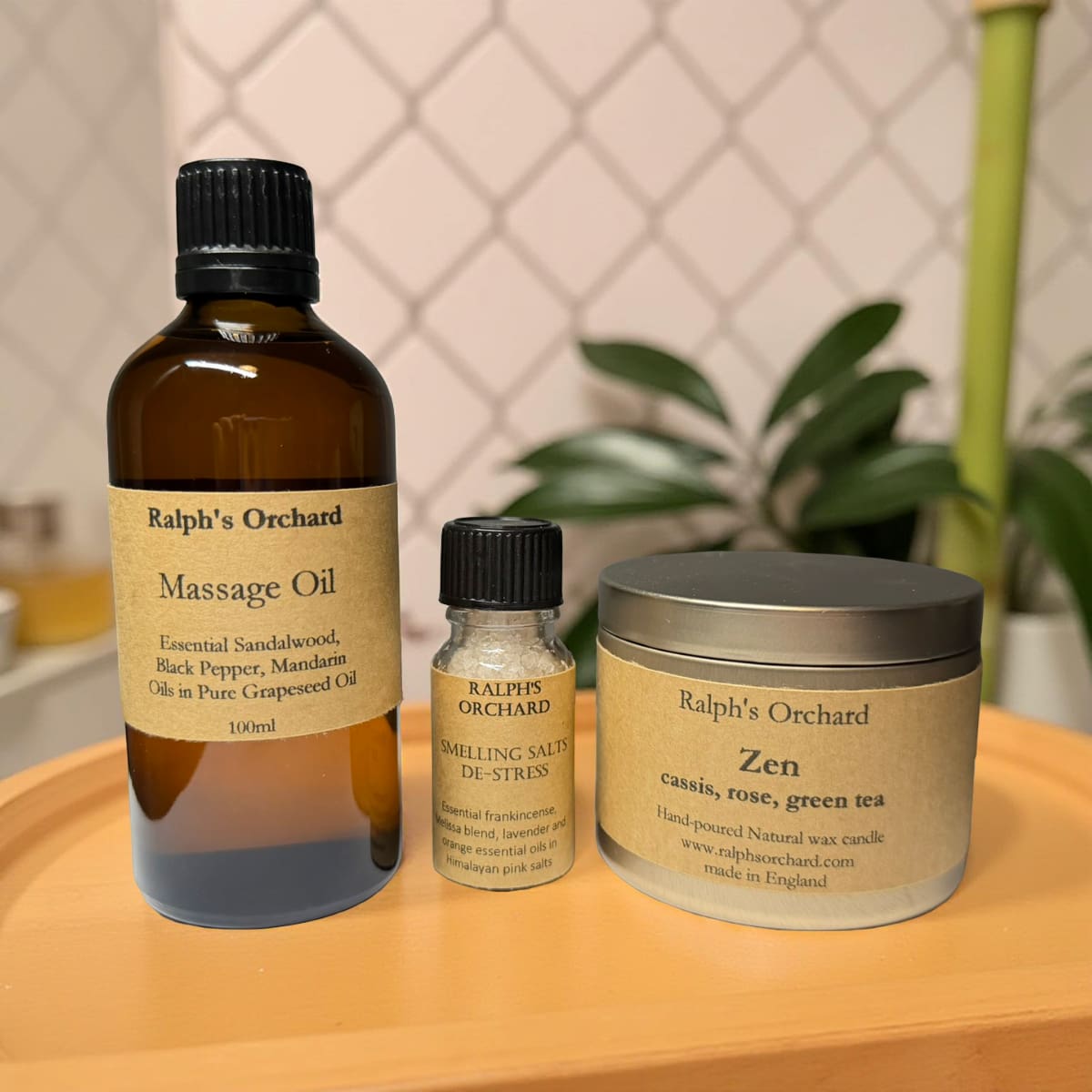 Three Ralph's Orchard products on a wooden surface with a plant in the background.