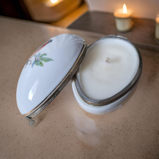 Candle in a decorative jar with a lid on a speckled countertop.