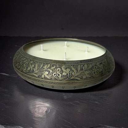 Decorative candle in an ornate holder on a dark surface