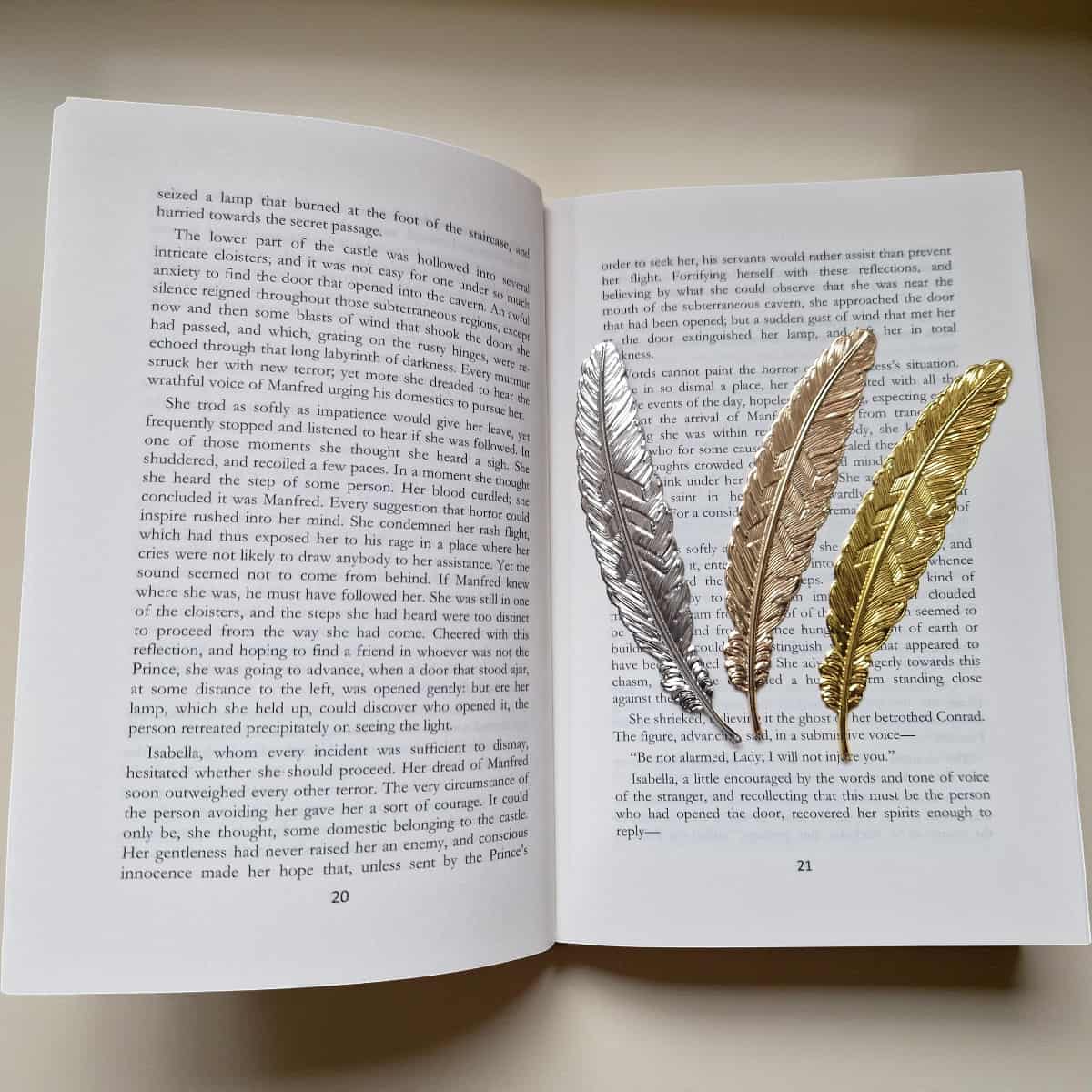 Three feather-shaped bookmarks on an open book