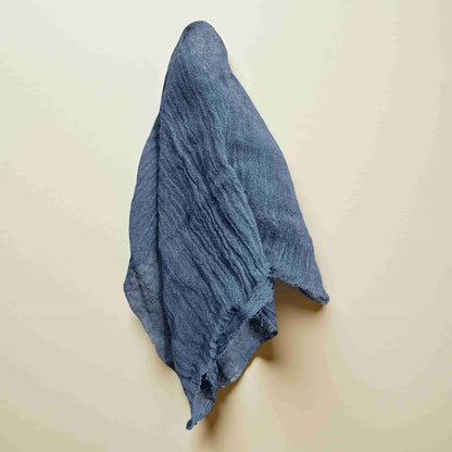 Blue gauze draped over a light beige wall