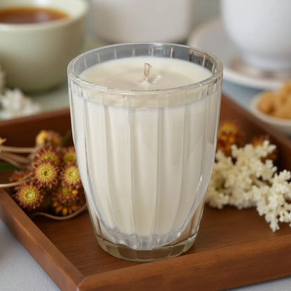 Glass candle on a wooden tray with decorative elements