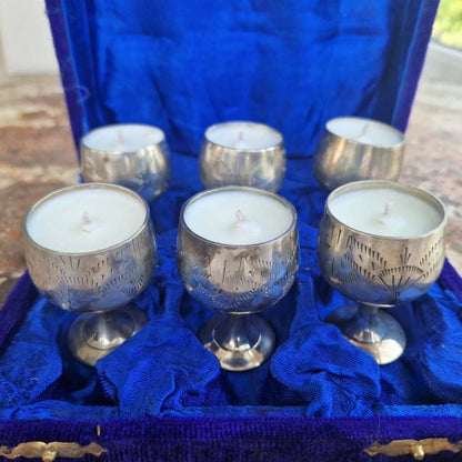 Silver candle holders with candles on a blue cloth