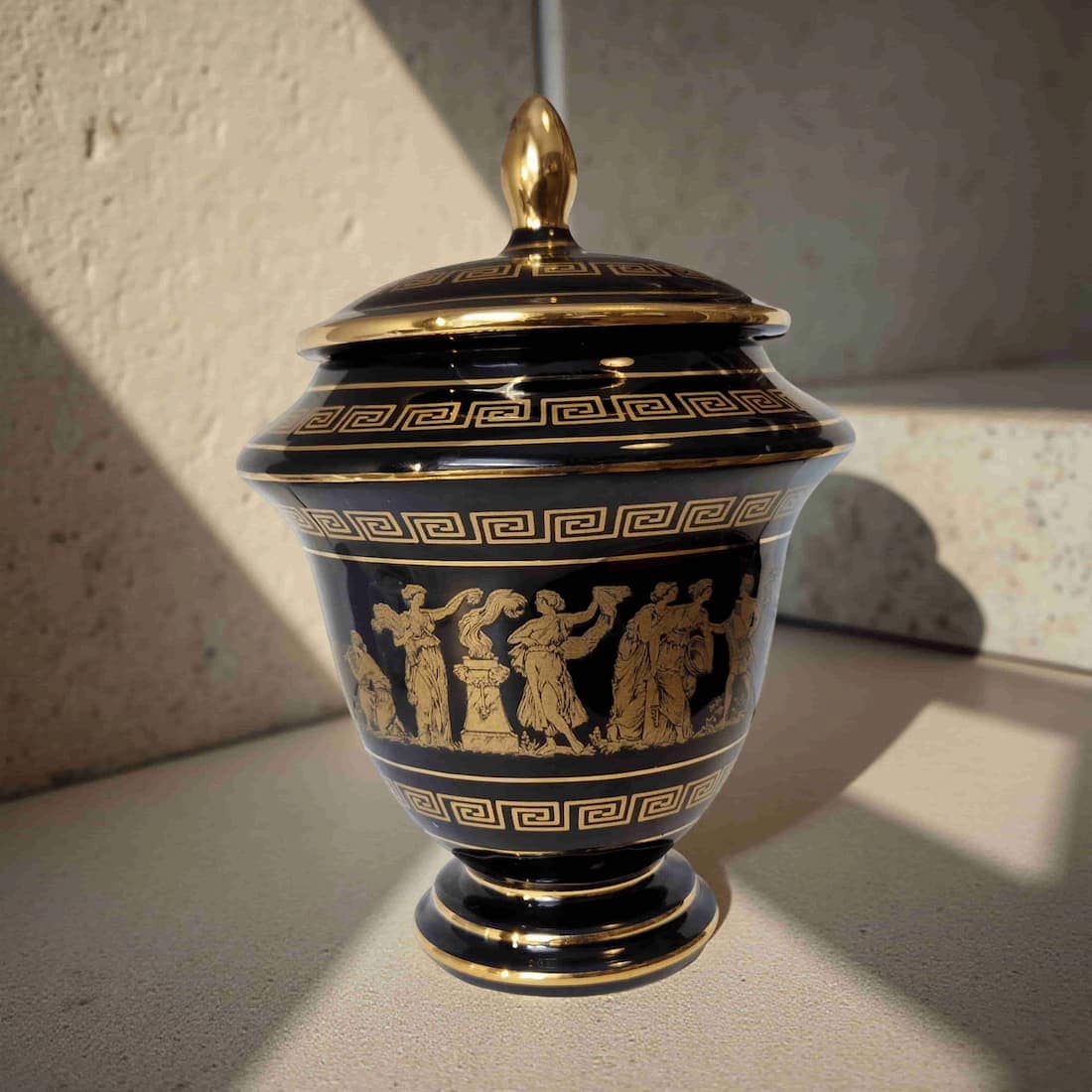 Decorative urn with gold detailing on a neutral background
