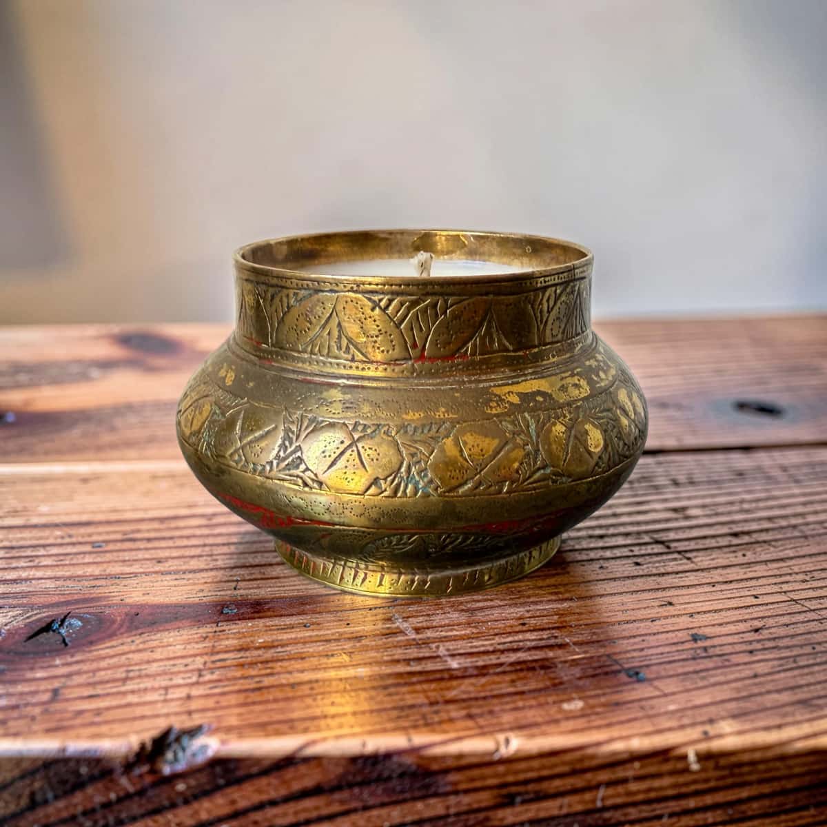 Decorative brass pot on a wooden surface