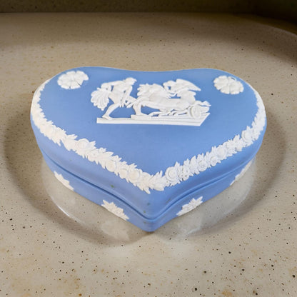 Heart-shaped blue and white decorative box on a beige surface