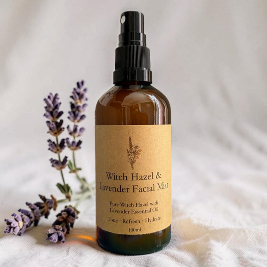Bottle of Witch Hazel & Lavender Facial Mist with lavender flowers on a soft fabric background