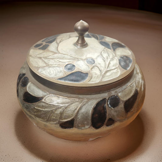 Decorative ceramic jar with a lid on a beige surface
