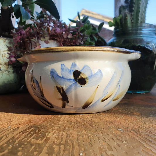 Ceramic pot with floral design on a wooden surface