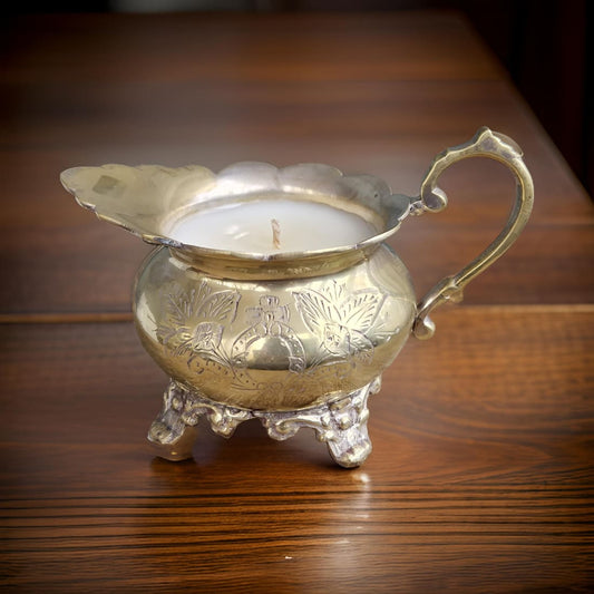 Decorative silver candle holder with a candle on a wooden surface