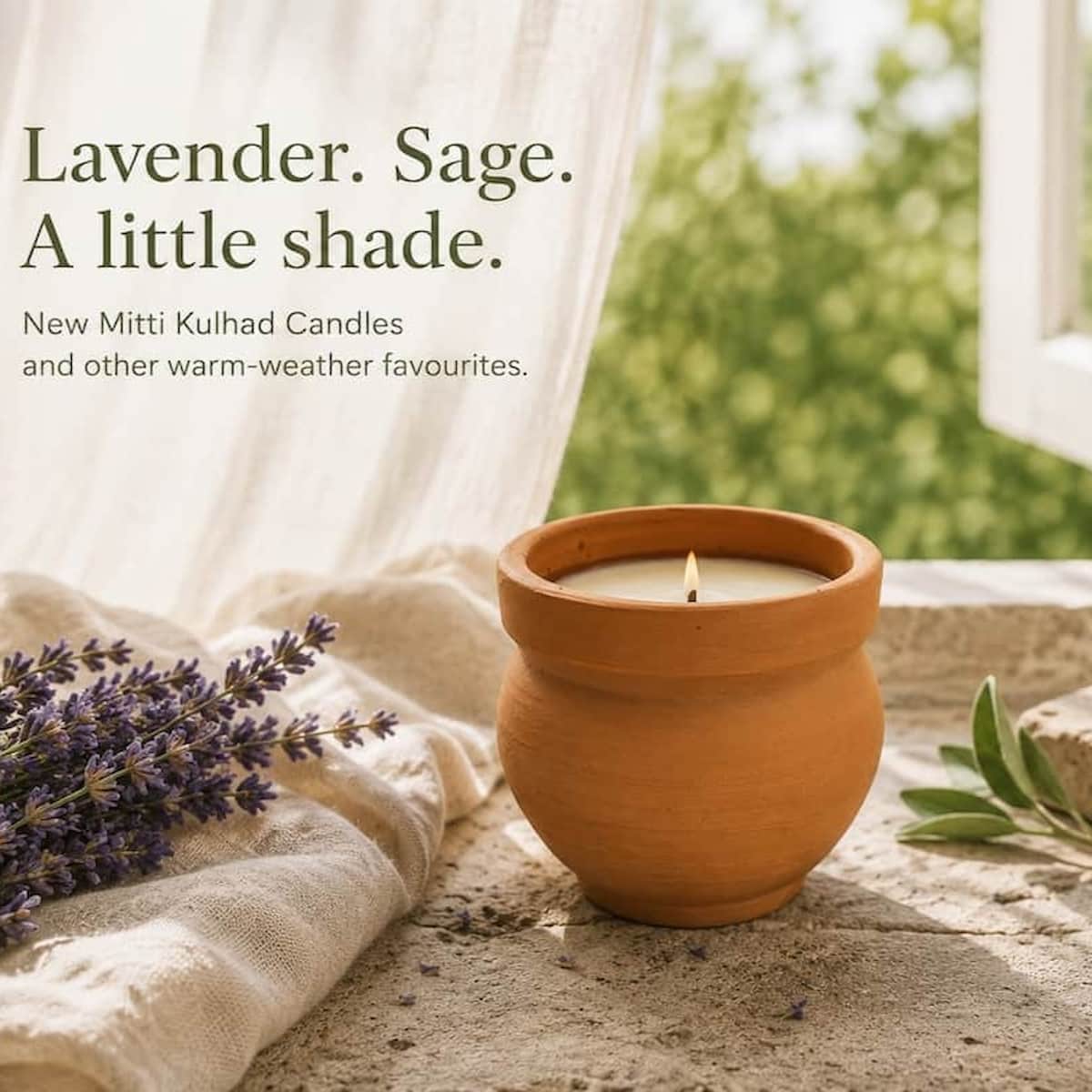 Candle in a terracotta pot with lavender and sage text on a blurred natural background