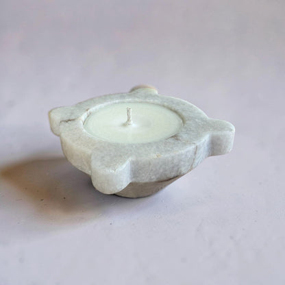 Candle in a stone holder on a light gray background