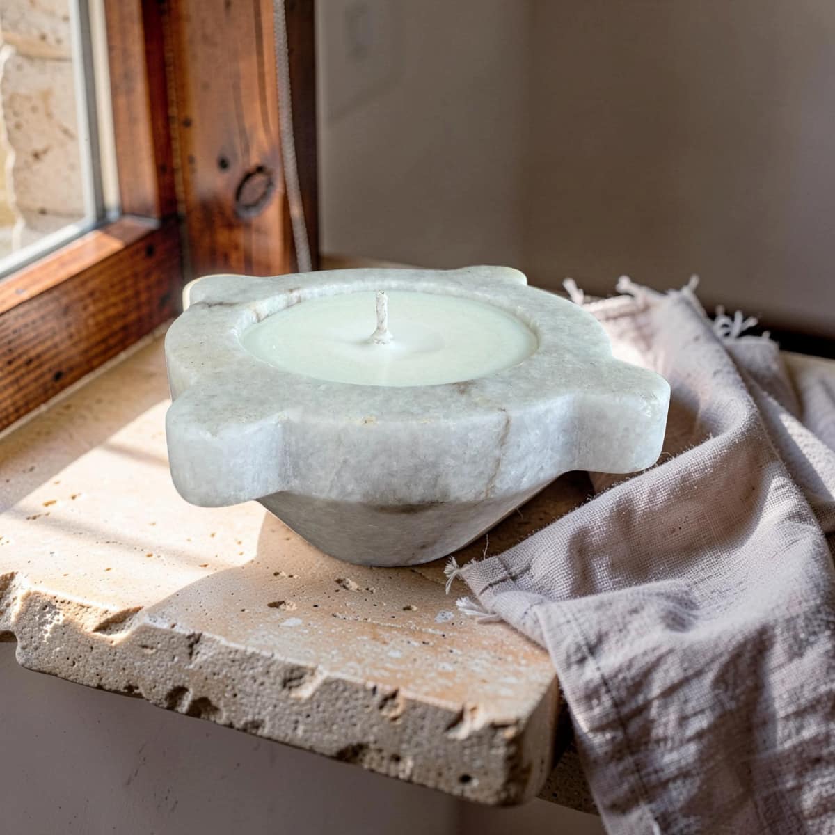 Marble candle holder with a candle on a wooden surface