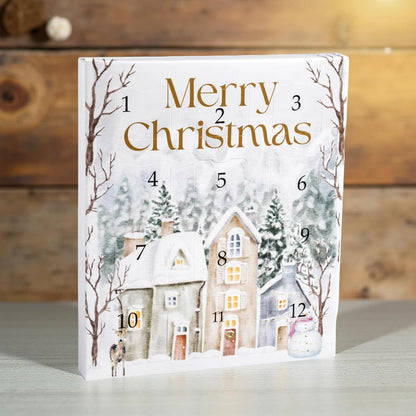 Advent calendar with snowy village design and 'Merry Christmas' text on a wooden background
