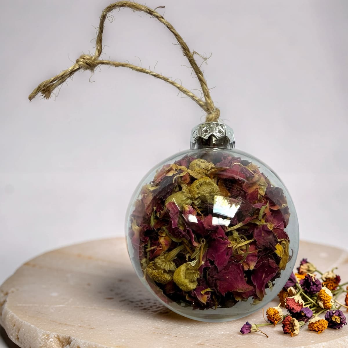 Clear bauble filled with dried rose petals, calendula and chamomile flowers
