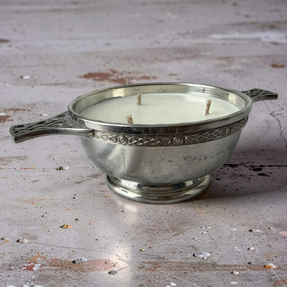 Silver candle holder with a candle on a rustic wooden surface