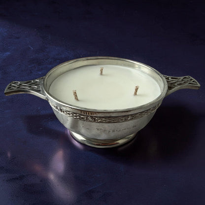 Decorative candle in a silver holder on a dark blue background