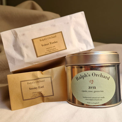 Candle packaging with 'Ralph's Orchard' branding on a neutral background