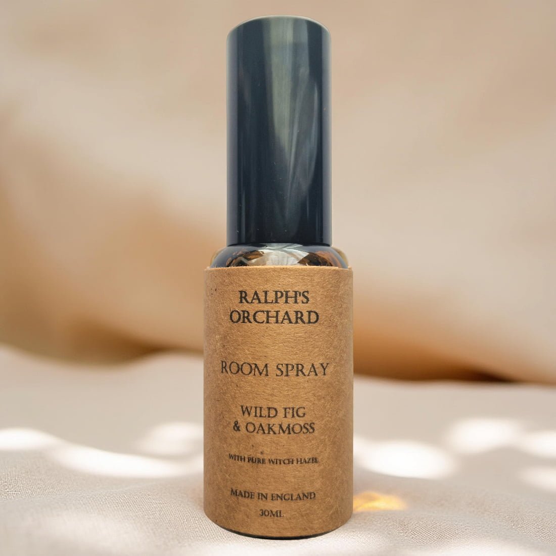 Room spray bottle labeled 'Ralph's Orchard' on a beige background