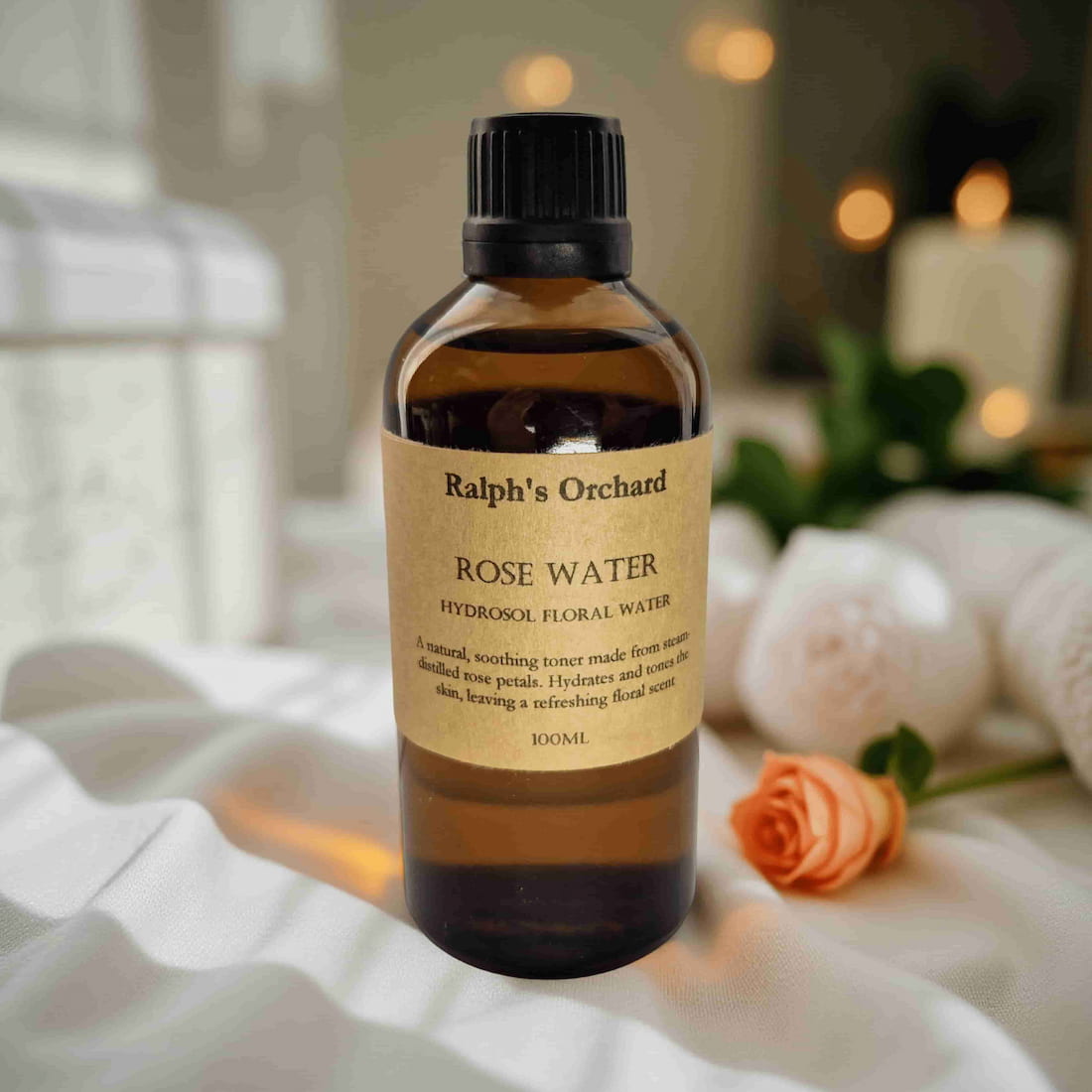 Bottle of Ralph's Orchard Rose Water on a soft surface with a blurred background
