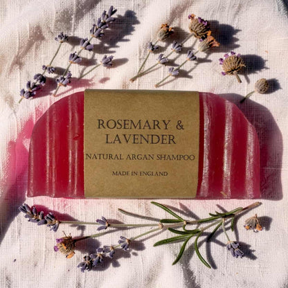 Bar of soap labeled 'Rosemary & Lavender' with lavender flowers on a textured fabric background