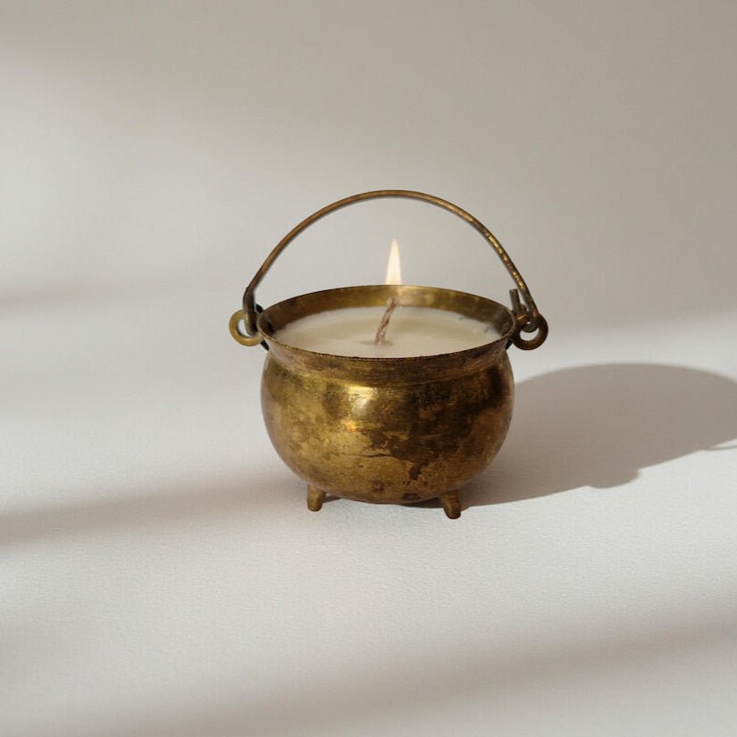 Candle in a brass container on a white background