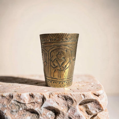 Bronze cup with intricate designs on a stone surface