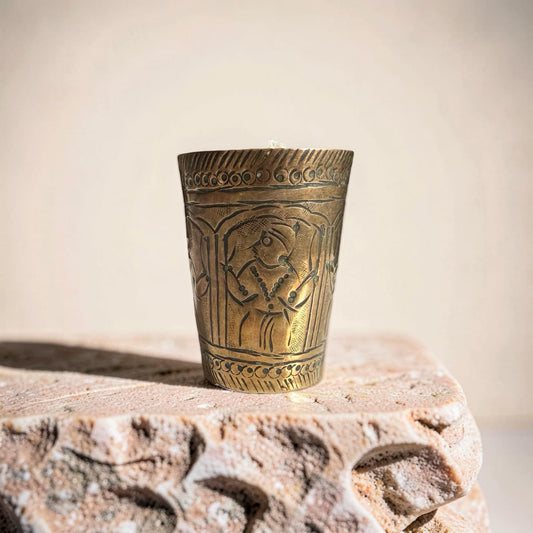 Bronze cup with intricate designs on a stone surface
