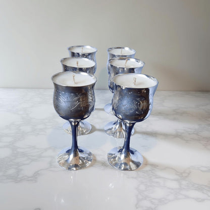 Set of six silver wine glass candles on a marble surface