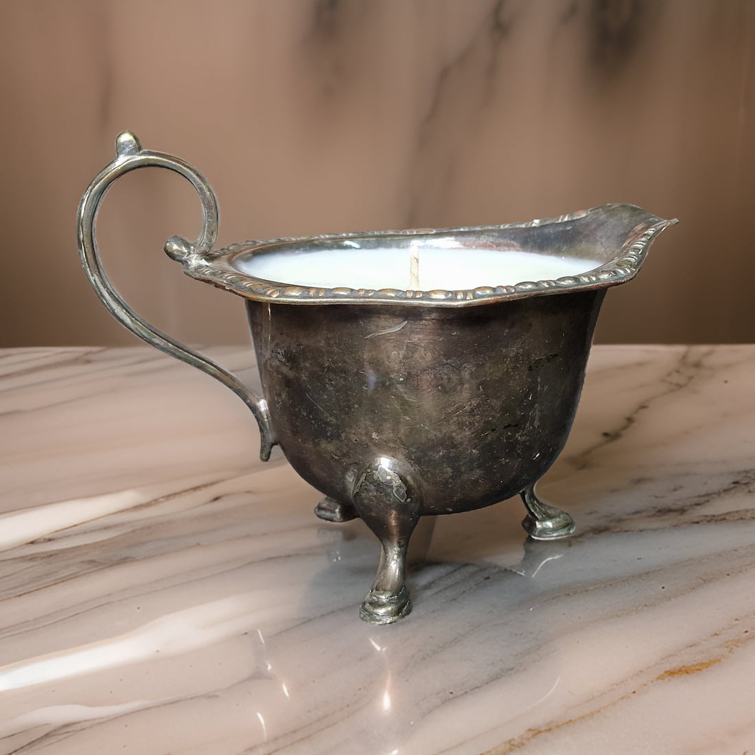 Silver gravy boat on a marble surface