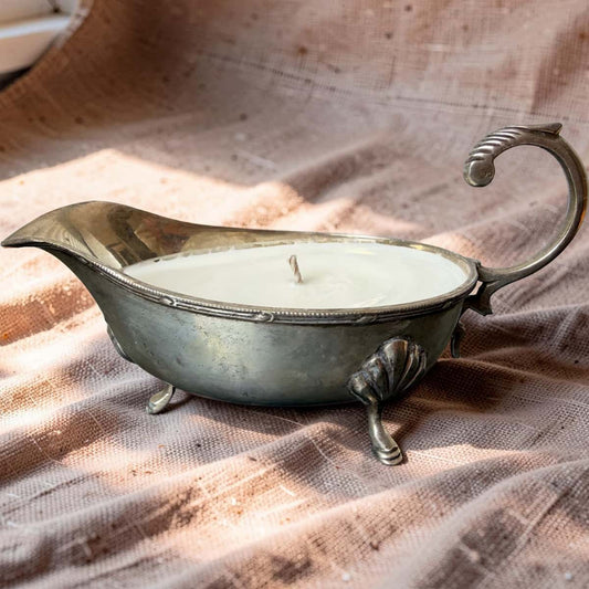 Decorative candle in a vintage-style metal holder on a textured fabric background