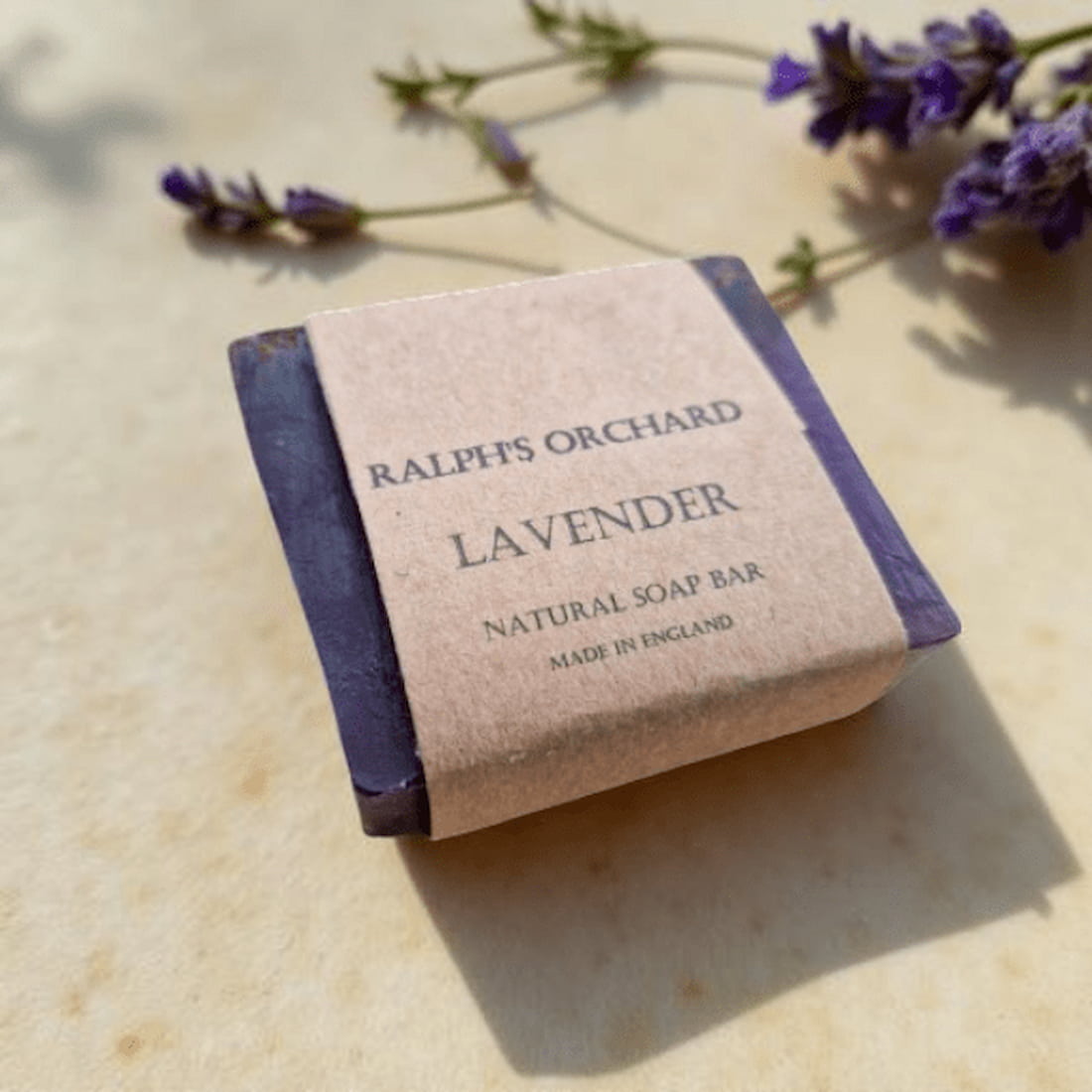 Ralph's Orchard Lavender natural soap bar on a light surface with lavender flowers.