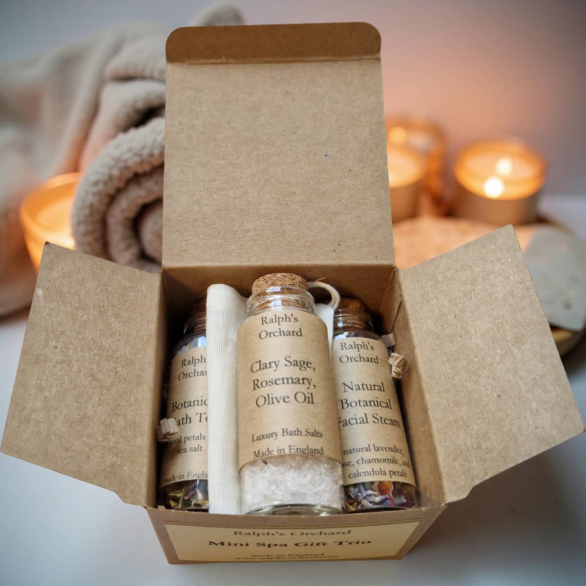 Box of Ralph's Orchard mini spa gift set with candles in the background