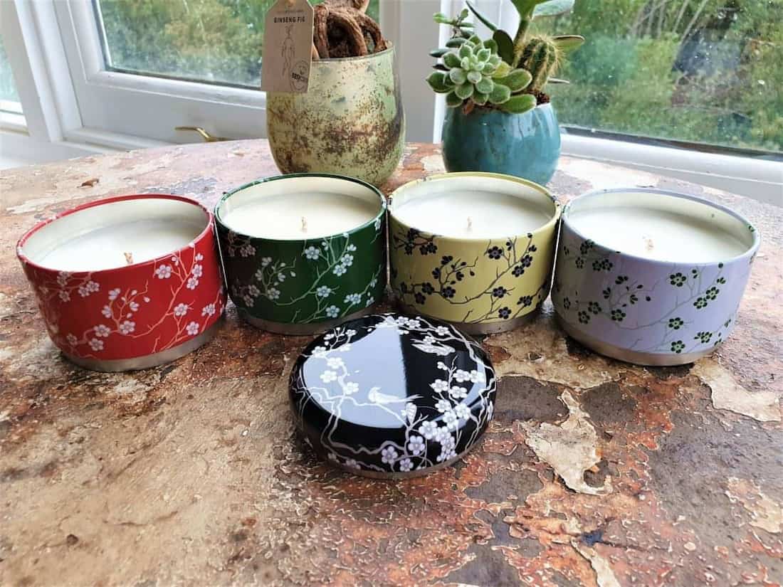 Set of colorful candles with floral designs on a textured surface.