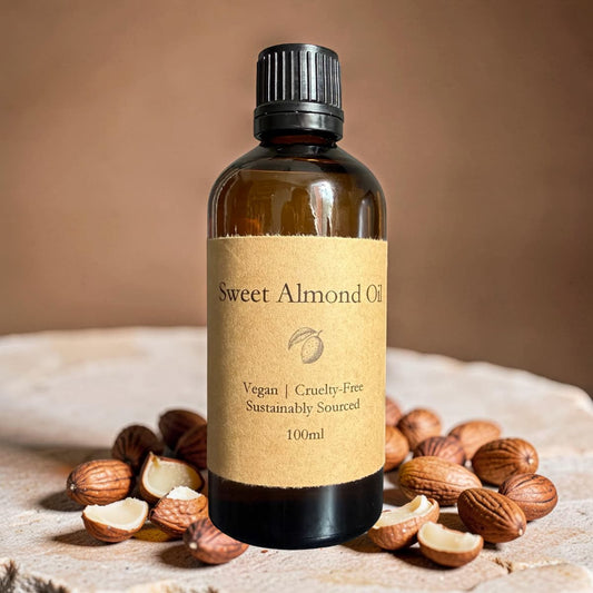 Bottle of sweet almond oil with almonds on a textured surface