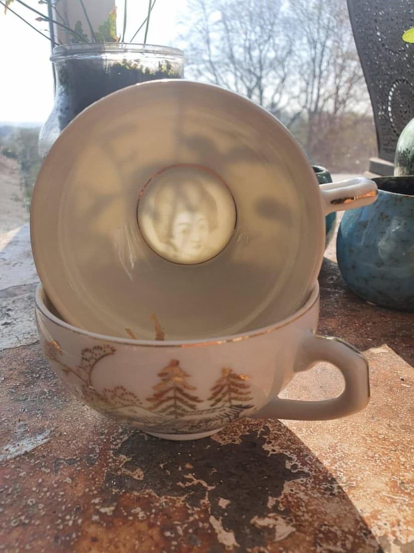 Stacked ceramic cups with a decorative design on a textured surface