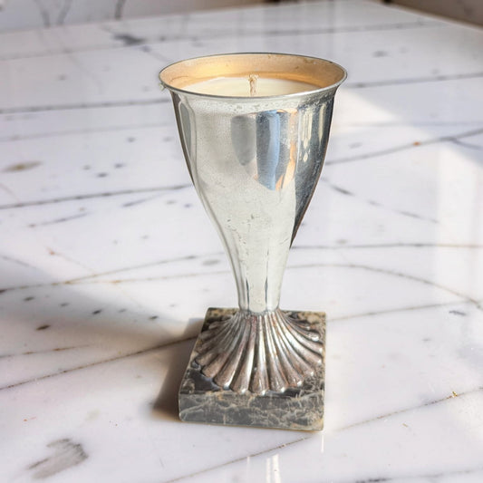 Decorative candle holder with a candle on a marble surface