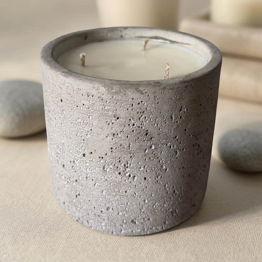 Cement container with a candle on a neutral background