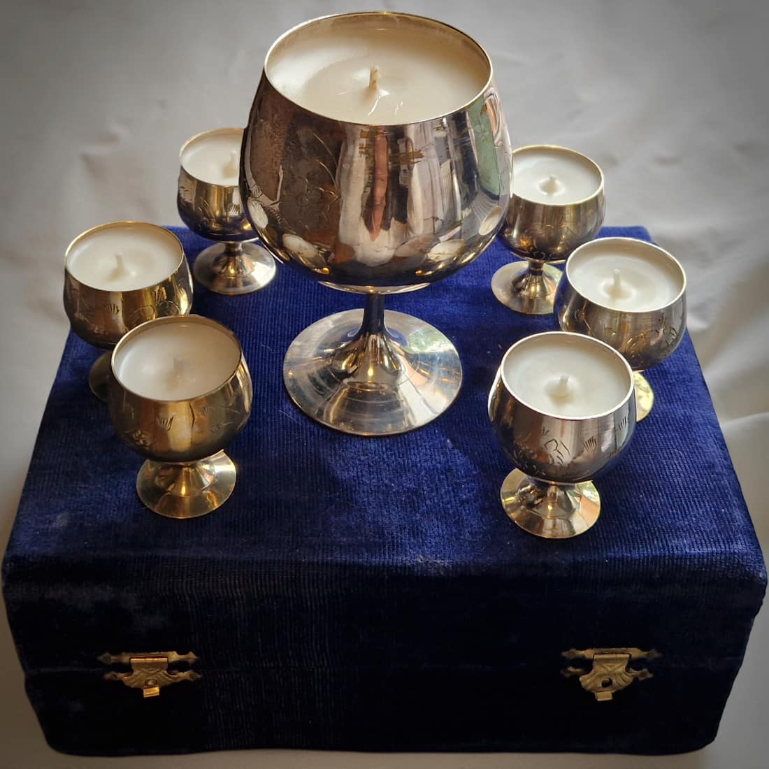 Silver goblets with candles on a blue box