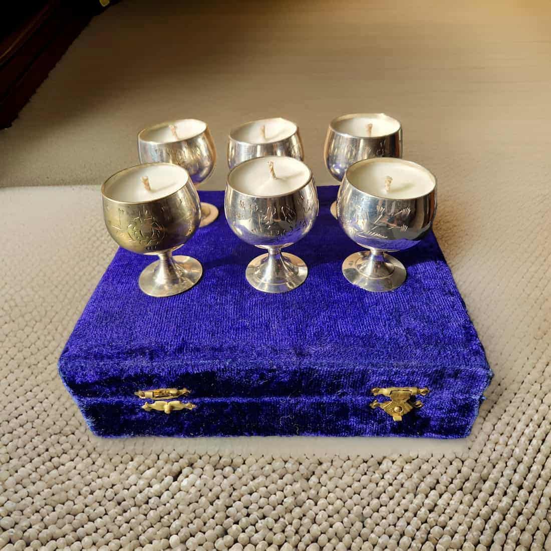 Silver candle holders on a blue velvet box on a textured surface